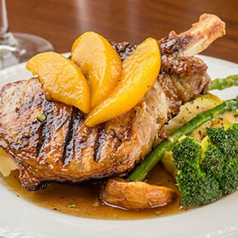 Columbo's - 10oz Pork Chop with Bourbon glazed peaches - American Near Me - Columbia, South Carolina Columbo's - 10oz Pork Chop with Bourbon glazed peaches - American Near Me - Columbia, South Carolina