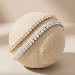 West Orange Jewelers - Lafonn tennis-inspired sparkle featuring gold and silver diamond tennis bracelets resting on a tennis ball, celebrating the w...