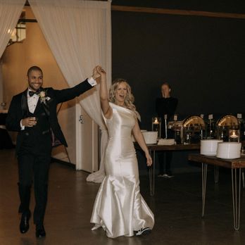 SKYLIGHT - A bride and groom dance together at their wedding reception, with the groom in a tuxedo and the bride in a satin wedding gown, in a decorated event space. - Venues & Event Spaces Near Me - Denver, Colorado