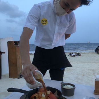 INTI Beach - Staff pouring the Peruvian red sauce that made the meal delicious! It has a little kick of   and a secret ingredient?! - Peruvian Near Me - Playa del Carmen, ROO