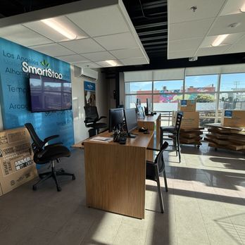 SmartStop Self Storage - Reception desk - The image shows the reception area of SmartStop Self Storage with desks, chairs, and boxes near large windows. - Self Storage Near Me - San Gabriel, California