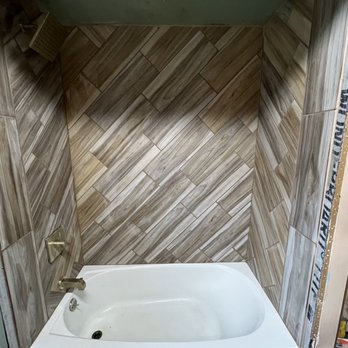 Woodwrx - a bathtub in the corner of a bathroom - General Contractors Near Me