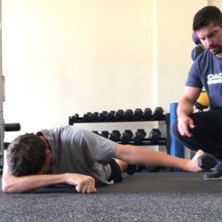 CoachMeFit - Pictured here is Head Coach Derek coaching Jason through a shoulder exercise.  Jason's goal is to increase his swing speed.
