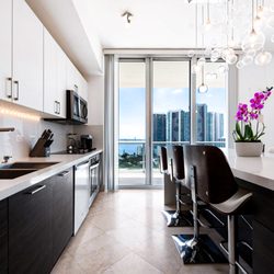 TREND Transformations of Sunrise - Miami Condo Kitchen Rennovation. Countertops: Polar Ice. Cabinets: Wenge Colored Slab Doors