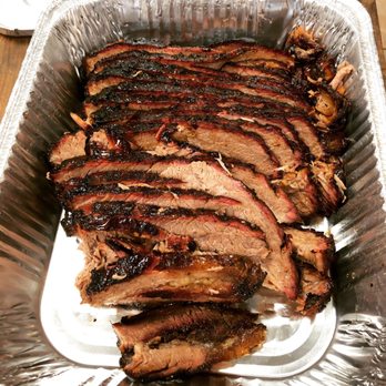 Sliced brisket in an aluminum tray.