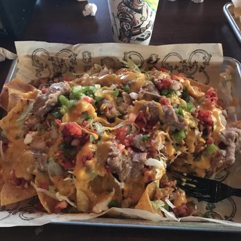 Tijuana Flats - Nachos,steak, refried beans, rice, salsa, fajita veggies, sour cream, queso, lettuce, tomatoes, onions, guacamole and sweet chili sauce - Mexican Near Me - Jacksonville, Florida