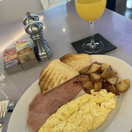 Mission breakfast (scramble eggs, ham, potatoes, and sourdough toast), mimosa