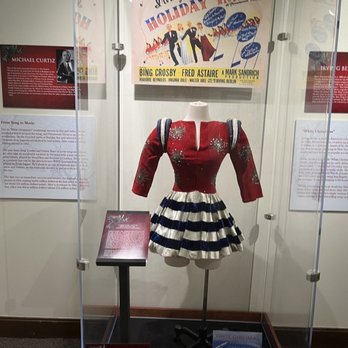Behringer-Crawford Museum - A red, white, and blue vintage costume on a mannequin is displayed inside a glass case at the Behringer-Crawford Museum, with informational plaques and posters around. - Museums Near Me - Covington, Kentucky