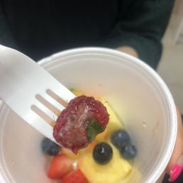 a person holding a fork and a bowl of fruit a person holding a fork and a bowl of fruit