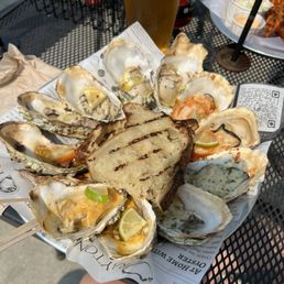 One dozen grilled oysters of various flavors.