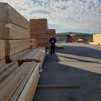 Boulder Builders, Inc. - a man standing in front of a pile of lumber - General Contractors Near Me - Valencia, California