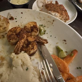 River & Post - Seafood shrimp, scallops and fish Mahi - A partially eaten seafood meal featuring shrimp, mashed potatoes, and vegetables, with a side of fish and a dipping sauce in a small bowl. - Lounges Near Me - Jacksonville, Florida