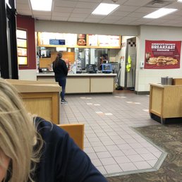 a woman sitting at a table in a fast food restaurant a woman sitting at a table in a fast food restaurant