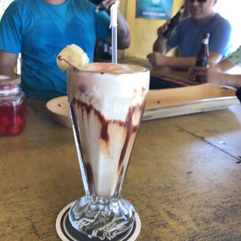 el norte - a man in a blue shirt sitting at a table with a sundae in front of him - Bars Near Me - San Pedro, California