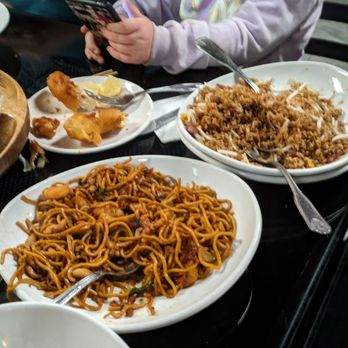 Wei-Li - Pork fried rice and house lo mein - A dining table with various Chinese dishes such as fried rice, lo mein, and stir-fried noodles, with utensils and empty plates. - Chinese Near Me - Auburn, Maine