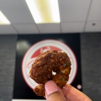 Belly's Sliders & Wings - a hand holding a piece of food - Food Trucks Near Me - Carson, California
