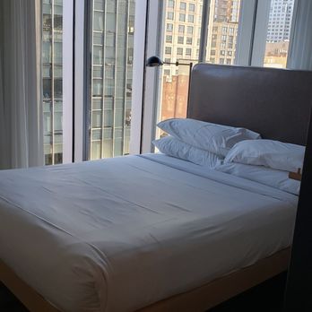 Moxy Boston Downtown - Bed with city view. (Corner room) - Hotels Near Me - Boston, Massachusetts