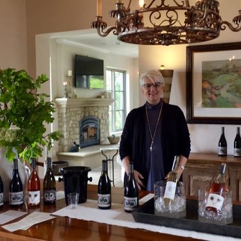 La Chouette Vineyard - a woman standing at a table with bottles of wine - Wineries Near Me - Jefferson, Oregon