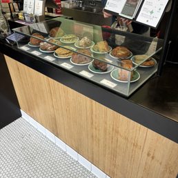 Front counter: pastry case, menu, and cash register