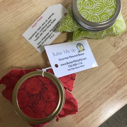 a jar of butter next to a red flower a jar of butter next to a red flower
