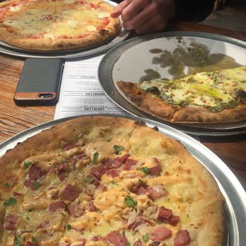 Masthead Brewing - Rueben pizza (front), Basil Pesto (half eaten), 4 Cheese. - Breweries Near Me - Cleveland, Ohio Masthead Brewing - Rueben pizza (front), Basil Pesto (half eaten), 4 Cheese. - Breweries Near Me - Cleveland, Ohio