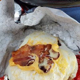 One piece of bacon on a baconator breakfast sandwich. One piece of bacon on a baconator breakfast sandwich.