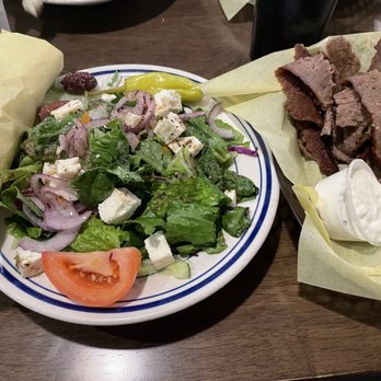 Pappoule's - Small Greek salad with gyro - A plate of Greek salad with lettuce, tomato, onion, feta cheese, and olives, accompanied by fried meat strips with a dipping sauce. - Greek Near Me - Tucson, Arizona