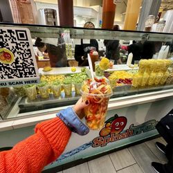 Splash Fruits - Mango Twist in front of the fruits display