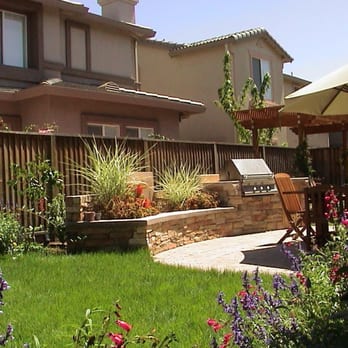 Limon Landscape - Cozy backyard landscape with an all in one waterfall-planter seat wall, small BBQ grill with counter top... - Landscaping Near Me