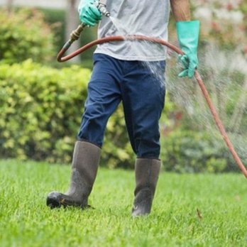 Bozeman Site Services - a man using a hose to water a lawn - Snow Removal Near Me - Belgrade, Montana