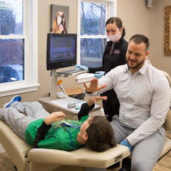 Peluso Orthodontics - Dr. Peluso giving a high-five to a young and brave patient. - Orthodontists Near Me - North Attleboro, Massachusetts Peluso Orthodontics - Dr. Peluso giving a high-five to a young and brave patient. - Orthodontists Near Me - North Attleboro, Massachusetts
