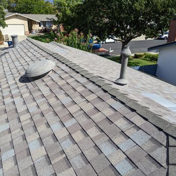 Integrity Roofing Systems - A residential roof with asphalt shingles, vents, and a chimney, overlooking neighboring houses and trees in a suburban area. - Roofing Near Me - Pleasanton, California