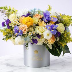 Pink Clover - Blue irises and hydrangea with yellow carnations, peach roses, chamomile and solidago in a silver box.