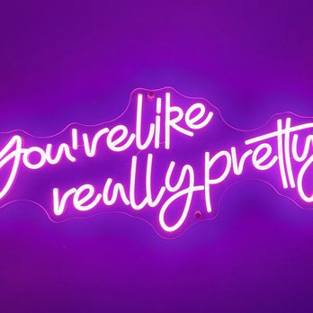 Kaliburger - In the ladies - A neon sign features the phrase "you're really pretty" written in cursive style with pink and purple neon lights. The sign is mounted on a purple wall, with visible wiring and mounting points, creating a vibrant and colorful visual effect. - Burgers Near Me - St. Augustine, Florida