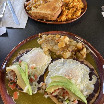Arango Cafe - Huevos Rancheros and Chorizo Hash - Two plates of Mexican breakfast food are shown, featuring huevos rancheros with eggs, avocado, and salsa, and chorizo hash with potatoes. One plate includes toast and sides. - Mexican Near Me - Kingston, New York