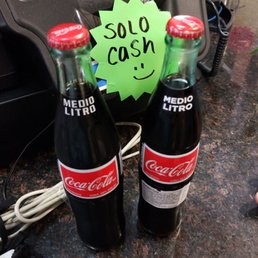two coke bottles with a sold sign two coke bottles with a sold sign