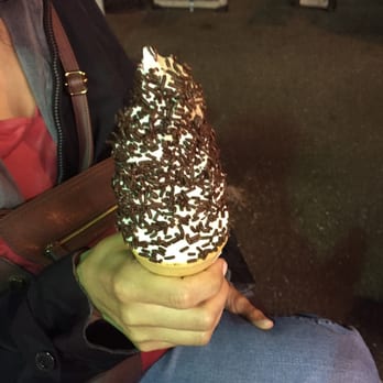 Mr. Cone - a woman sitting on a bench holding a cone of chocolate and sprinkled sprinkles - Fast Food Near Me - Chicopee, Massachusetts