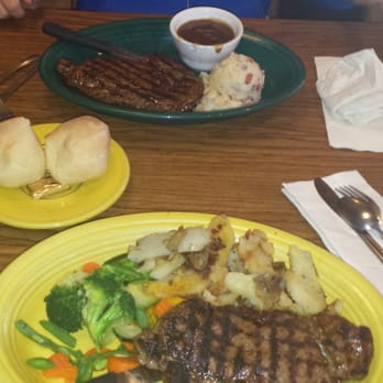 Outpost Cafe - Top is rib eye with garlic mashed potatoes and bottom is New york steak with home fries and veggies, great food guys!!! - American Near Me - Oak Hills, California Outpost Cafe - Top is rib eye with garlic mashed potatoes and bottom is New york steak with home fries and veggies, great food guys!!! - American Near Me - Oak Hills, California
