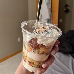 a person holding a cup of cake a person holding a cup of cake