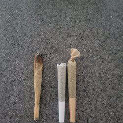 Curaleaf - Left - partially smoked home rolled joint Right - 2 separate pre-rolled joints from curaleaf