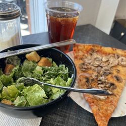 Enzo's Pizza - Half Caesar salad and a slice. I added mushrooms. Fresh seasonings on table.
