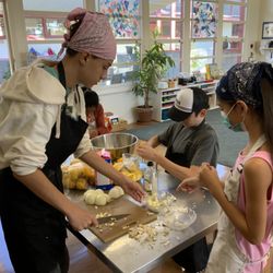 Oak Knoll Montessori School - Adolescent students help elementary students prepare hot lunch.