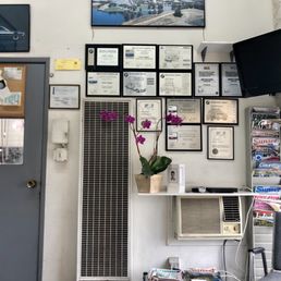 Wall of certificates, awards, and a TV