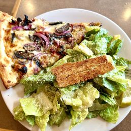 a plate of salad and a slice of pizza a plate of salad and a slice of pizza