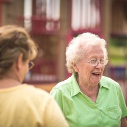 1776 Senior Care - A caregiver sharing a joyful conversation with a senior, reflecting 1776 Senior Care's commitment to providing compassionate ...
