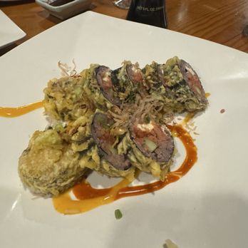 Sushi Pure - Tempura sushi rolls with avocado, fish, and vegetables are served on a white plate, garnished with sauces and green onions. - Sushi Bars Near Me - Eugene, Oregon