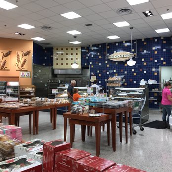 Publix - a woman in a pink shirt standing in front of a counter - Grocery Near Me - Fleming Island, Florida