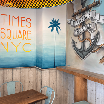 Playa Bowls - Times Square - a table and chairs in a restaurant - Acai Bowls Near Me - New York, New York Playa Bowls - Times Square - a table and chairs in a restaurant - Acai Bowls Near Me - New York, New York
