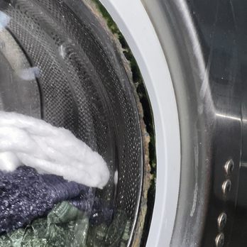 Breeze Laundry - YUCK . Sad to say these are my towels that i am now going to have to rewash somewhere cleaner - A front-loading washing machine with water inside, showing dirt and grime buildup around the door seal and drum. - Laundry Services Near Me - Springfield, Missouri
