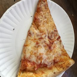 Cheese Pizza - A large triangular cheese pizza slice with melted cheese and tomato sauce on a white paper plate.